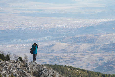 Photographer in action on Mountains with a nice viewの写真素材