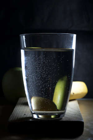Water With Apple and Banana served on wooden base on black background textureの写真素材