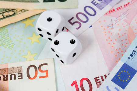 Two dice on money bills background