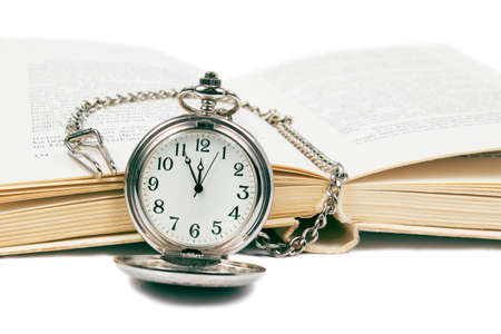 Vintage pocket watch with book on white backgroundの写真素材