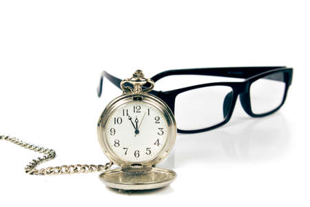 Vintage pocket watch and glasses on white background