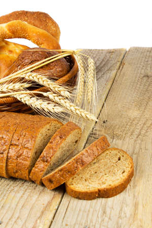 Slices of bread with wheat on a wooden surfaceの写真素材
