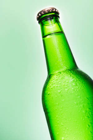 Beer bottle isolated on a green backgroundの写真素材