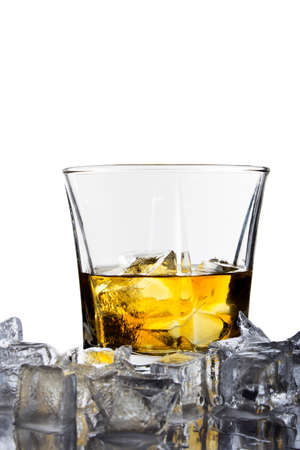 A glass of whiskey with ice cubes on white backgroundの写真素材