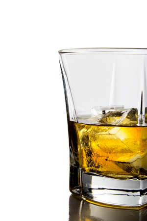 A glass of whiskey with ice cubes on white backgroundの写真素材