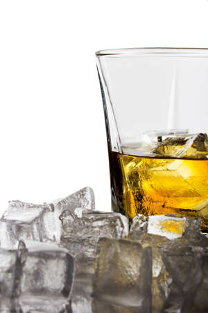 A glass of whiskey with ice cubes on white backgroundの写真素材