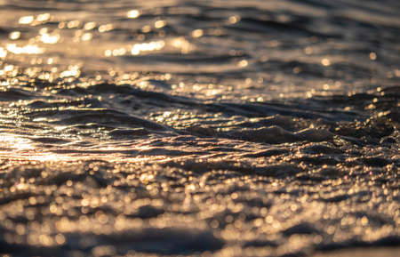 sea wave closeup macro at sunset timeの写真素材