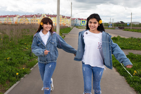 the Two happy girls in denim suitsの写真素材