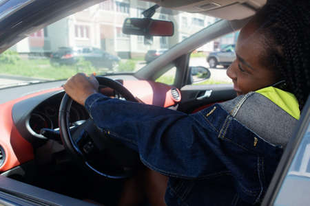 the African American woman in the car talking on the phone