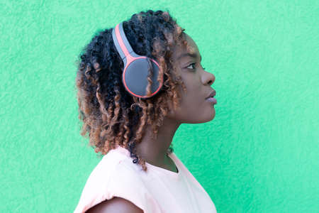 the beautiful African American woman in headphones on the streetの写真素材