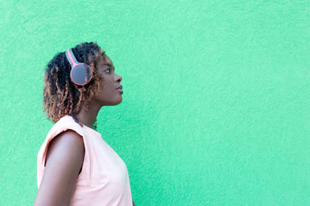 the beautiful African American woman in headphones on the streetの写真素材