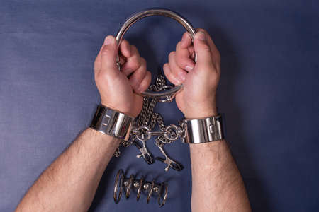the men's hands in handcuffs on a blue background, BDSM
