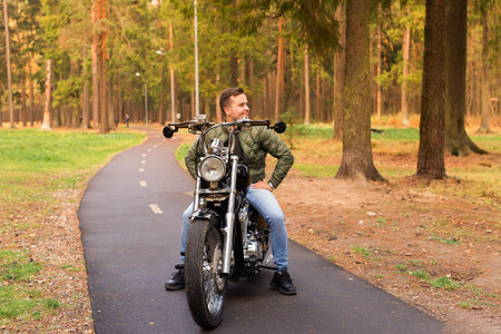 the Beautiful man sits on a motorcycle, road