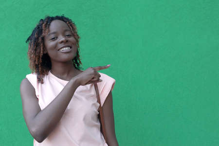Young beautiful happy African American woman on a green background