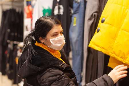 the Beautiful girl buys clothes in the storeの写真素材