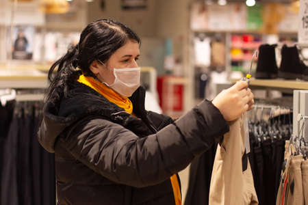 the Beautiful girl buys clothes in the store