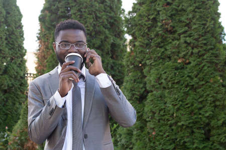 the Happy African American with phone and coffee