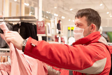 A masked man looks at the outer clothing.
