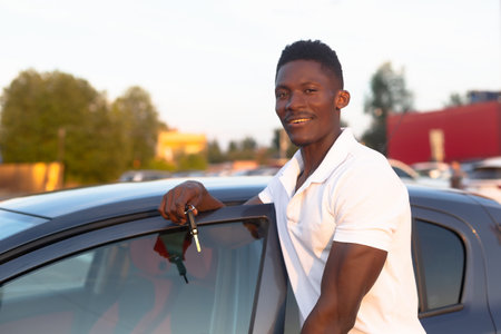 An African-American man holds a car key in his hands. Buying and renting a car.の写真素材