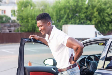 An African-American man gets out of the car. Human emotions.