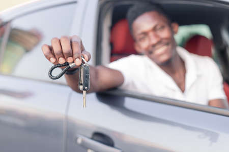 The key to the car is in the hands of an African-American. Buying and renting a car.の写真素材