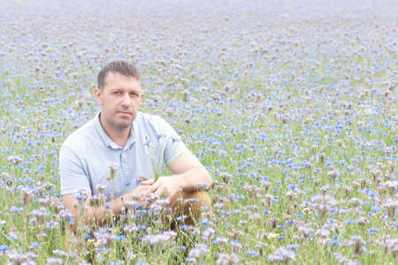 A happy man in a field of flowers. Beauty is in nature.の写真素材