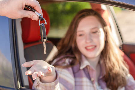 The girl takes the car key. Car sales and rentals.の写真素材