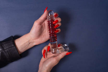 Dildo in hand on a blue background, sex toy. Leisure for adults.の写真素材