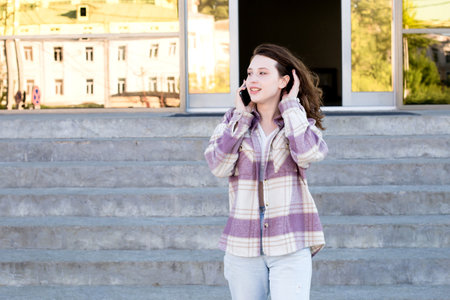 A young girl on the street with a phone in her hand. Lifestyle.