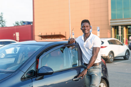 A smiling man holds the car keys in his hands. Car sales and rentals.の写真素材