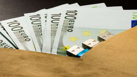money in an envelope on a black notepad background