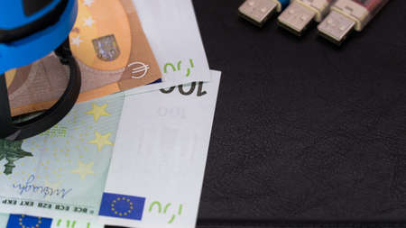 money in an envelope on a black notepad background