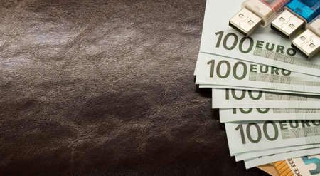 money in an envelope on a brown leather notepad backgroundの写真素材