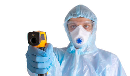 man wearing biological protective uniform suit clothing, mask, gloves measuring body temperature...