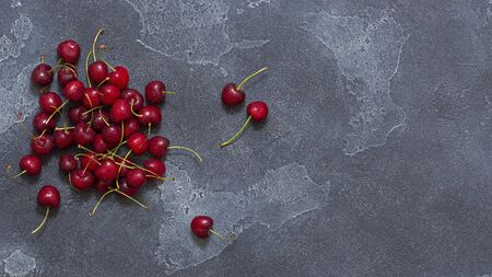 Fresh, ripe, sweet cherries with drops of water on a stone background. View from above.の写真素材