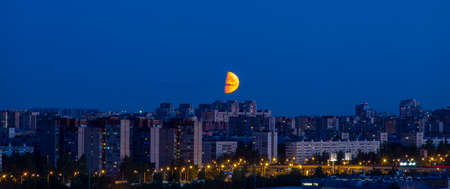 Dramatic Big red moon over the city. Summer night. Clear sky.