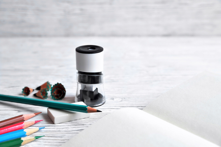 Pencils, notepad, sharpener, eraser and shavings from pencils on a gray non-uniform backgroundの写真素材