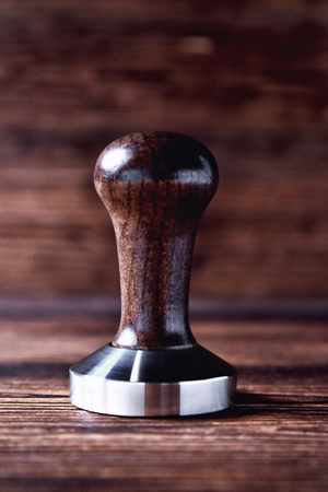 temper coffee beans on a brown wooden background blurの写真素材