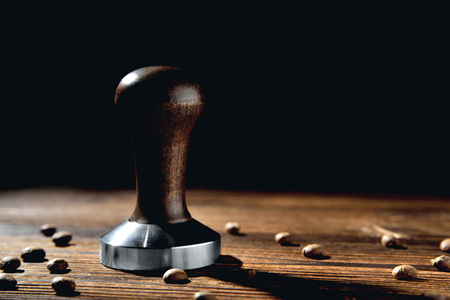 temper coffee beans on a brown wooden background blurの写真素材