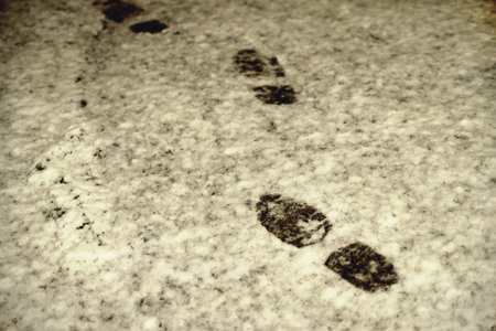 footprints in the snow at night by the light of a lantern, prints of men's shoes, close-up