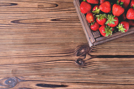 Strawberries in a wooden box on a natural wooden natural background, blur as an artistic technique of the author close-up copy spaceの写真素材