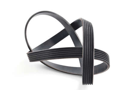 A new belt for a poly-V-ribbed electric generator. Car timing belt. White background close-up. Selective focusの写真素材