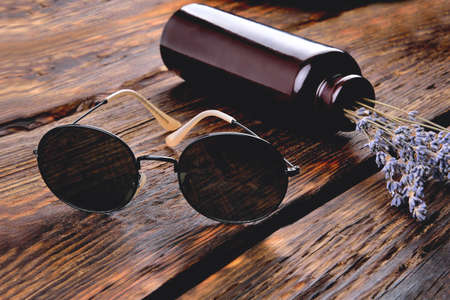 Sun glasses, stylish sunglasses on wooden background in rustic style background, close-up selective...