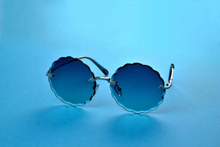 Glasses from the sun, stylish sunglasses on a blue background, close-up selective focus