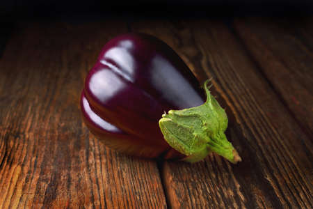 Eggplant on wooden background, fresh juicy vegetable on wooden rustic background, selective focus, soft focus, closeupの写真素材
