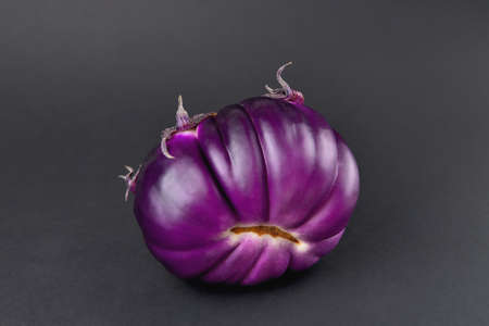 Eggplant on a black background, fresh juicy vegetable on a dark background, soft focus, close-upの写真素材