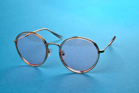 Glasses from the sun, stylish sunglasses on a blue background, close-up selective focusの写真素材