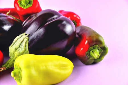 Eggplant and sweet peppers on a purple background, fresh juicy vegetables on a colored background, selective focus, soft focusの写真素材