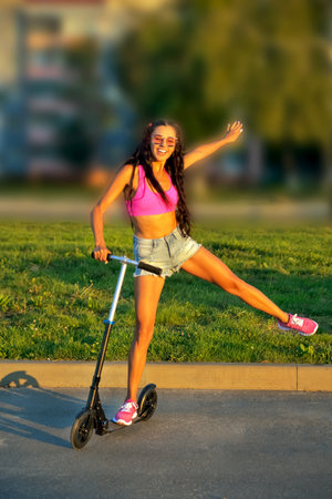 scooter riding. smiling beautiful girl on scooter, sunny day close-up selective focusの写真素材