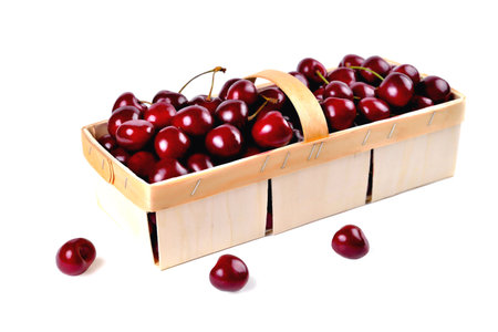 Ripe natural cherries, sweet cherries in a birch bark basket on a white background, close-up selective focusの写真素材